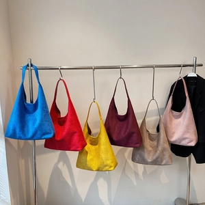 Six different colors of large capacity suede shoulder hobo bags hanging on a display rack