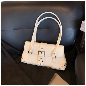 Nahaufnahme der cremefarbenen Ledertasche mit silbernen Metallschnallen und Nieten
