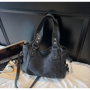Détail d'un grand sac fourre-tout gris foncé avec rivets métalliques et bandoulière amovible