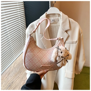 Detail of pink plaid hobo bag featuring a metal logo and a cute plush rabbit charm