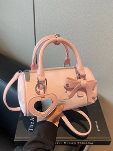 Pink cylinder handbag with bow and heart mirror charm in glossy leather finish