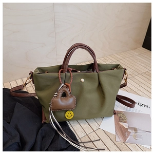 Sac fourre-tout en toile vert olive avec poignées en cuir marron et breloque décorative