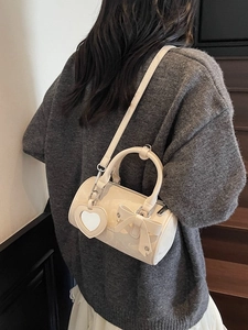Cream bow cylinder handbag with heart mirror charm and adjustable shoulder strap