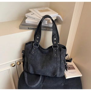 Gros plan du sac cabas gris vintage avec rivets argentés et anneaux métalliques