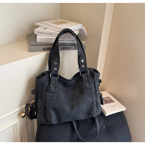 Détails du sac cabas en cuir mat gris foncé avec des accents de rivets en métal argenté