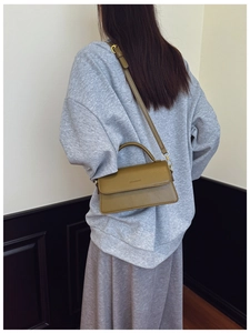 Model view of an olive green crossbody bag with a top handle and gold hardware