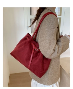 Detailed view of dark red suede tote bag with slim straps and elegant silver buckle accent
