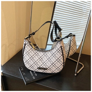 Detail of checkered crescent bag with black leather trim and golden metal hardware