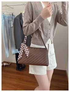 Detail of dark brown woven shoulder bag with chic white polka dot silk scarf handle