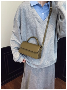 Close-up of olive green vintage mini square bag with leather handle and crossbody strap