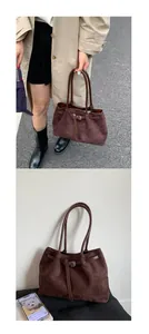 Detail of dark brown suede tote bag featuring slim strap buckle and vintage texture