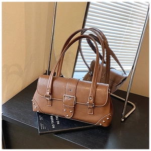 Detail der braunen Vintage-Schultertasche mit silbernen Nieten und Metallschnalle