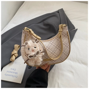 Detail of beige plaid hobo bag with leather strap and cute plush sheep pendant