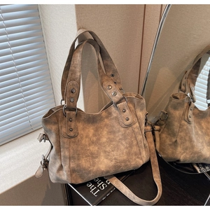 Détail d'un sac cabas marron vintage en similicuir avec rivets et bandoulière réglable