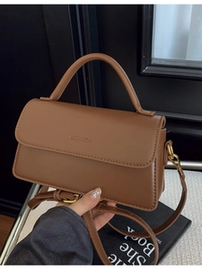 Vintage brown leather crossbody bag with top handle and golden metal hardware detail