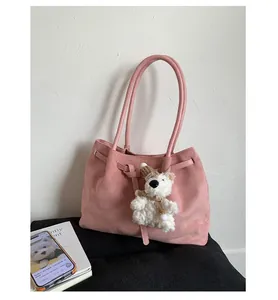 Pink faux suede shoulder bag with a cute bear plush pendant and drawstring detail