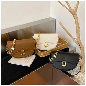 Detail of three saddle bags with gold chain decor and D-ring buckles in varied colors