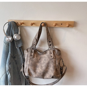 Détails du sac fourre-tout vintage en cuir marron avec rivets métalliques sur un crochet