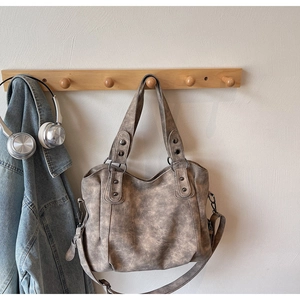 Détail d'un sac cabas vintage en cuir marron suspendu avec des accessoires de mode