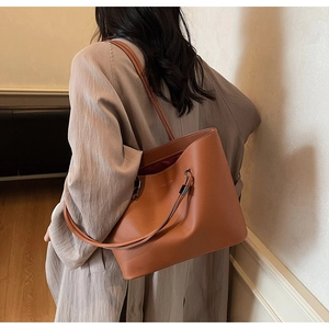 Detail view of brown faux leather tote bag with lychee texture and logo print