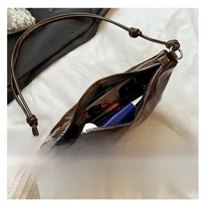 Detail view of large brown patent leather hobo bag showing spacious interior capacity