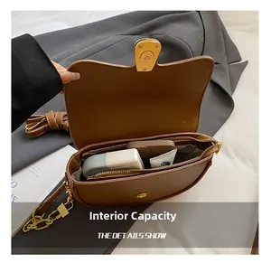 Internal capacity of the brown leather saddle bag showing phone and cosmetics