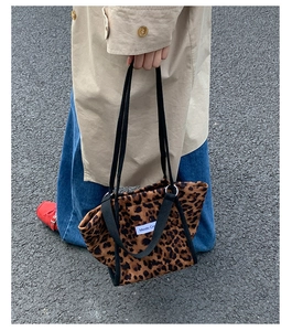 Gros plan du sac fourre-tout à motif léopard avec bandoulière noire et trench-coat beige