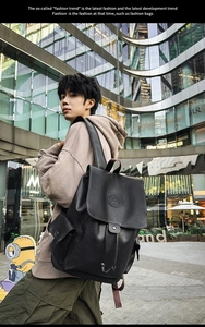 Detail of black faux leather backpack with drawstring closure and magnetic flap