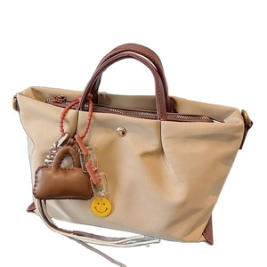 Sac bandoulière en toile plissée beige avec poignées marron et breloque smiley