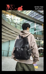 Detail of a vintage black leather backpack with drawstring closure and buckle flap shown on back