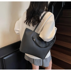Detail of black pebbled leather tote with white stitching and Laurel & Love logo detail