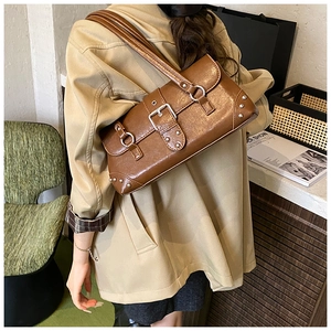 Detail einer braunen Vintage-Schultertasche aus PU-Leder mit silbernen Nieten