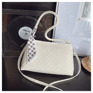 Detail shot of cream woven tote with herringbone texture and polka dot silk ribbon