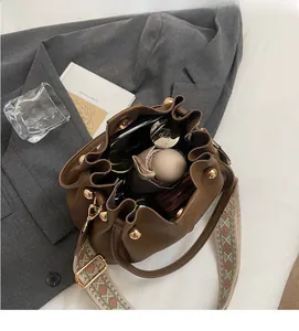 Brown litchi leather bucket bag interior showcasing spacious storage and woven strap