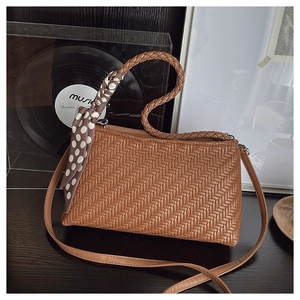 Close-up of brown woven texture bag with decorative polka dot silk scarf detail