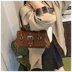 Nahaufnahme der braunen Retro-Schultertasche mit großer Schnalle und Metallnieten