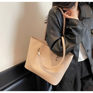 Close-up of beige faux leather tote bag with lychee texture and metallic hardware detail