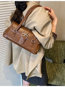 Braune Retro-Schultertasche aus Leder mit Silberschnalle und Nieten am Model