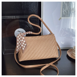 Detail shot of woven shoulder bag with silk scarf and high-quality leather texture