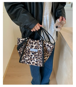 Détail du sac fourre-tout à motif léopard avec poignées noires et étiquette logo