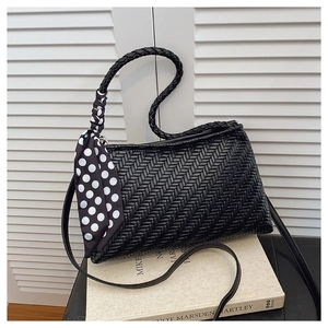 Detail of black woven shoulder bag with polka dot scarf and textured artisan handle