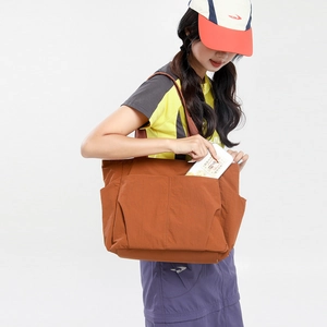 Caramel nylon tote bag showing side functional pockets and large storage capacity