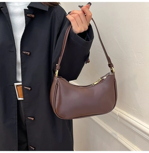 Detailed macro view of dark coffee crescent hobo bag with gold hardware and smooth leather