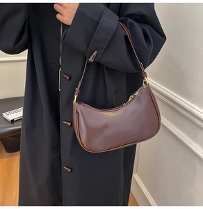 Detail of dark brown leather hobo bag with gold zipper and adjustable shoulder strap