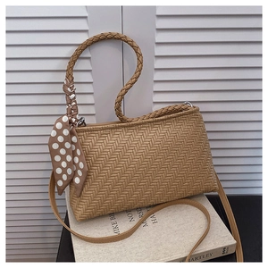 Detail of coffee woven shoulder bag with polka dot scarf on handle and zipper closure