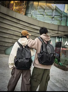 Detailed view of black vintage leather backpack with drawstring closure and side pockets