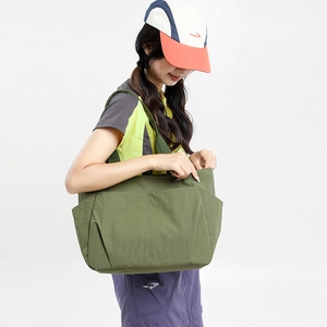 Detail view of military green nylon tote bag with multi-pocket design and durable stitching