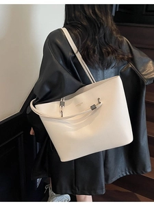 Minimalist cream pebbled leather tote bag with gold metal buckle and spacious design
