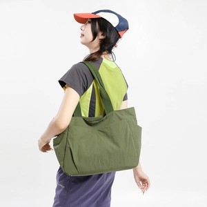 Detailed side view of green large capacity nylon tote bag with functional side pockets