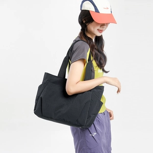 Side view of large black nylon tote bag showing spacious side pockets for storage